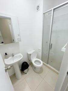 La salle de bains est pourvue de toilettes, d'un lavabo et d'une douche. dans l'établissement Exclusivo departamento en condominio con Piscina, à Piura