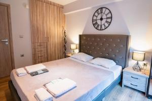 1 dormitorio con 1 cama grande y reloj en la pared en Lux Modern Apt Ανακαινισμένο διαμέρισμα 150m από την πλαζ 'ΈΔΕΜ', en Atenas