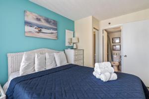 een slaapkamer met een bed met blauwe muren bij Beautiful 2 Bedroom Apartment in Cherry Grove with Stunning Views Buena Vista 402 in Myrtle Beach