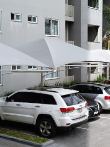 a white suv parked in a parking lot in front of a building at APTO ACONCHEGANTE proximo ao centro in Foz do Iguaçu