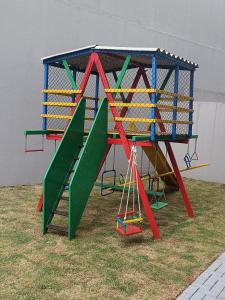 a playground with a colorful play set on the grass at APTO ACONCHEGANTE proximo ao centro in Foz do Iguaçu