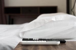 a remote control sitting on a table next to a bed at Sea Harmony in Adelianos Kampos