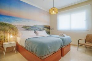 a bedroom with a bed and a painting of the beach at Mar y Puerto Best Location by Sol Maestranza in Marbella
