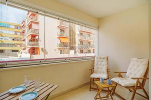 a room with a table and chairs and a large window at Mar y Puerto Best Location by Sol Maestranza in Marbella