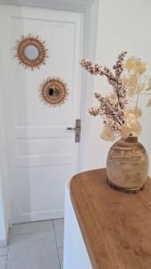 a vase with flowers on a table in front of a door at Casa Mina in Pietrosella