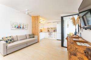 a living room with a couch and a kitchen at Acogedor Duplex en Ciutadella-Playa Santandria in Cala Santandria