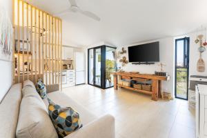 uma sala de estar com um sofá e uma televisão de ecrã plano em Acogedor Duplex en Ciutadella-Playa Santandria em Cala Santandria