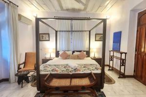 a bedroom with a canopy bed in a room at Stelliam's Luxury Heritage Suite in Campal, Goa in Panaji