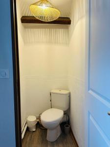 a small bathroom with a toilet and a light at Au Cosy in Guînes