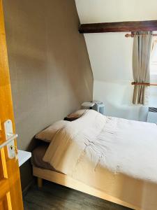 Au Cosy في Guînes: غرفة نوم مع سرير وحوض استحمام