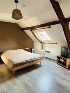 a bedroom with a bed and a tv in a room at Au Cosy in Guînes