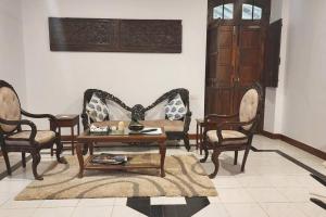 een woonkamer met stoelen en een tafel bij Stelliam's Luxury Heritage Suite in Campal, Goa in Panaji
