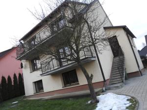 a building with a staircase and a tree in front of it at Apartament Florynka in Florynka