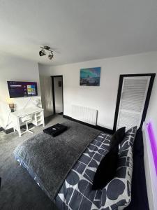 a bedroom with a large bed and a desk at Kensington Stories - 4 Bed House in Watford