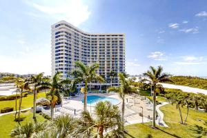 ein hohes Gebäude mit einem Pool und Palmen in der Unterkunft South Seas Serenity in Marco Island