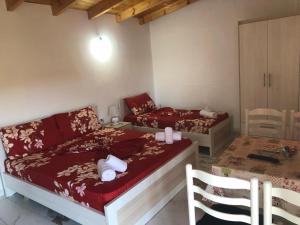 a small room with two beds and a table at Nino's rooms in Sarandë