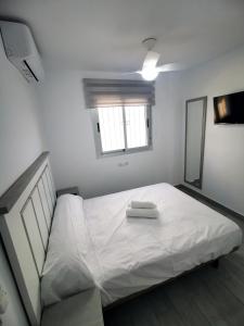 białe łóżko z dwoma ręcznikami na górze w obiekcie Barbate Alojamientos Turísticos w mieście Barbate