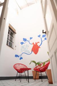 a room with two red chairs and a wall with a mural at Casa Miguel - Apartamento 1 in Sanlúcar de Barrameda