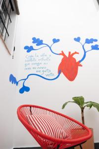 a red chair in front of a wall with a spider on it at Casa Miguel - Apartamento 1 in Sanlúcar de Barrameda +43 photos