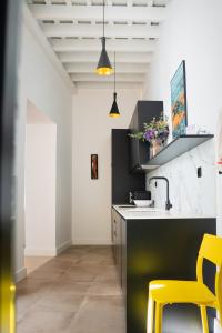 a kitchen with a yellow chair and a sink at Casa Miguel - Apartamento 1 in Sanlúcar de Barrameda