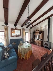 Una sala de estar con un sofá azul y una mesa. en Casa Rural Tita Sacramento, en Hornachos