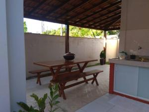 a table and bench in a kitchen with a counter at Duplex na Praia de Guriri in São Mateus