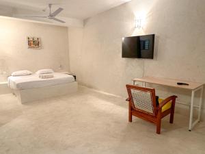 1 dormitorio con 1 cama, 1 mesa y 1 silla en Kaleb's Beachfront Serviced Studio Apartments, en Malindi