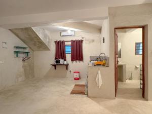 Habitación grande con cocina con cortinas rojas. en Kaleb's Beachfront Serviced Studio Apartments, en Malindi
