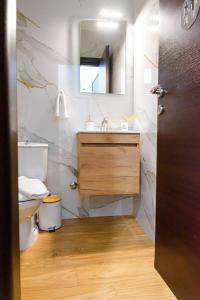 W łazience znajduje się umywalka, toaleta i lustro. w obiekcie Emi's House w mieście Ksanti