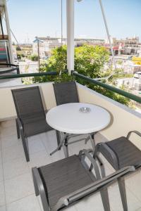 d'une table blanche et de deux chaises sur un balcon. dans l'établissement Stella's Apartment, à Alexandroúpolis