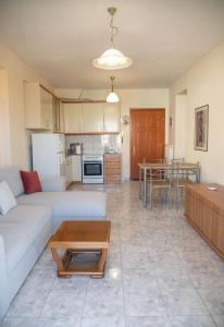 sala de estar y cocina con sofá y mesa en Stella's Apartment, en Alexandroupoli