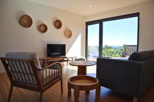 uma sala de estar com um sofá e uma televisão em Caju Villas Montargil - Villa Pedra Furada em Montargil