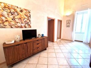 a living room with a flat screen tv on a wooden cabinet at Domus Chiara in Monopoli