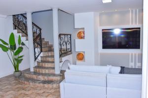 a living room with a white couch and a staircase at Casa Oásis do Moreno 6 in Vila Velha