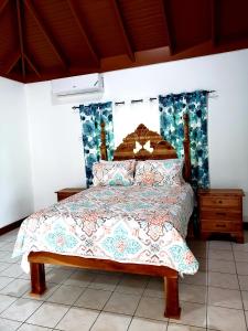 ein Schlafzimmer mit einem Bett mit einem Kopfteil aus Holz in der Unterkunft Cozy Apartment Greenwood in Montego Bay