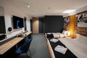 um quarto de hotel com duas camas e uma secretária em Velkov Apartments em Vinica