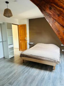 1 dormitorio con cama y techo de madera en Au Cosy en Guînes