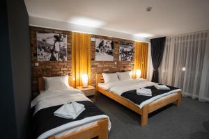 um quarto de hotel com duas camas e duas lâmpadas em Velkov Apartments em Vinica