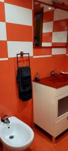 ein rot-weißes Bad mit einem Waschbecken und einem Spiegel in der Unterkunft Apartamento Ideal para Grandes Familias in Miramar