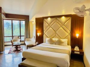una camera d'albergo con un grande letto e una finestra di River Grand View Resort and SPA Manali - A River side Property a Manāli