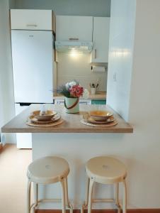 a kitchen with two stools and a table with two plates at La Berrea Cabañaquinta in Aller