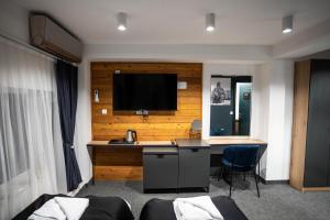 um quarto de hotel com uma secretária e uma televisão na parede em Velkov Apartments em Vinica