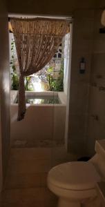 uma casa de banho com um WC e uma janela em Pakáal Muliix - Naranjo em Mérida
