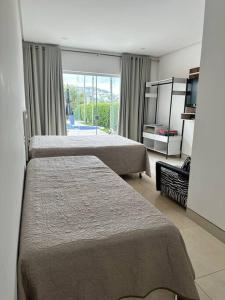 een hotelkamer met 2 bedden en een raam bij Luxo e Localização Privilegiada em Escarpas in Capitólio
