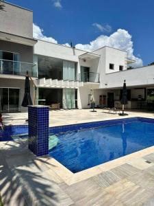een groot huis met een zwembad ervoor bij Luxo e Localização Privilegiada em Escarpas in Capitólio