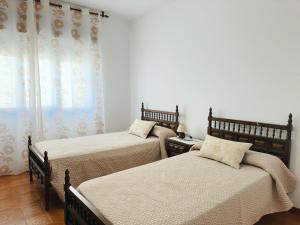 a bedroom with two beds and a window at Casa Sear-Bordóns in Sear