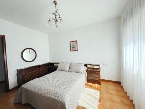a white bedroom with a bed and a mirror at Casa Sear-Bordóns in Sear