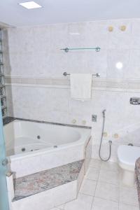 uma casa de banho com banheira e WC em Casa Oásis do Moreno 6 em Vila Velha