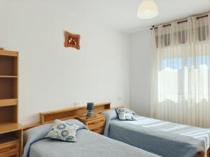 a bedroom with two beds and a window at Casa Sear-Bordóns in Sear