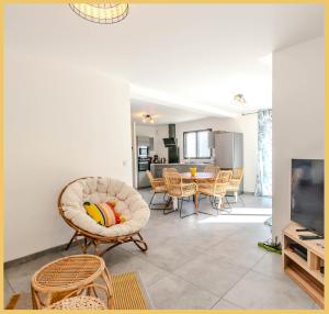 ein Wohnzimmer mit Tisch und Stühlen in der Unterkunft Zen Vanilla Home, Maison exotique entre Annecy et Geneve in Cruseilles